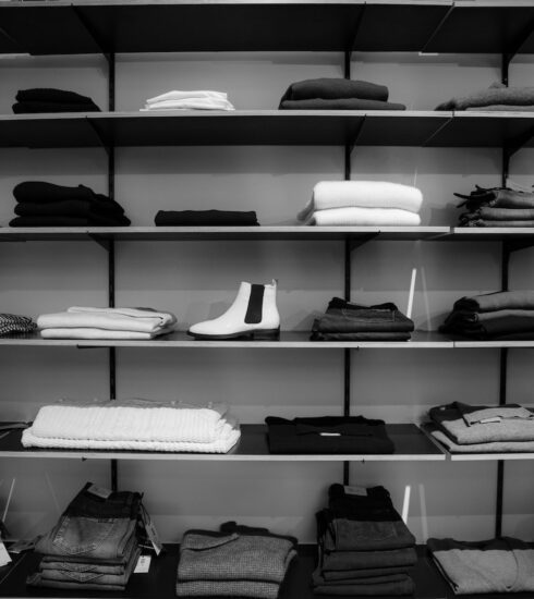 Grayscale Photography of Assorted Apparels on Shelf Rack