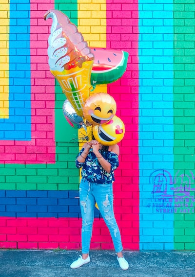 Woman Covering Face with Assorted Balloons