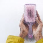 a person holding a hair brush in their hands